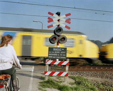 800815 Gezicht op met AKI's beveiligde spoorwegovergang in de Mereveldseweg te Utrecht, tijdens het passeren van een trein.